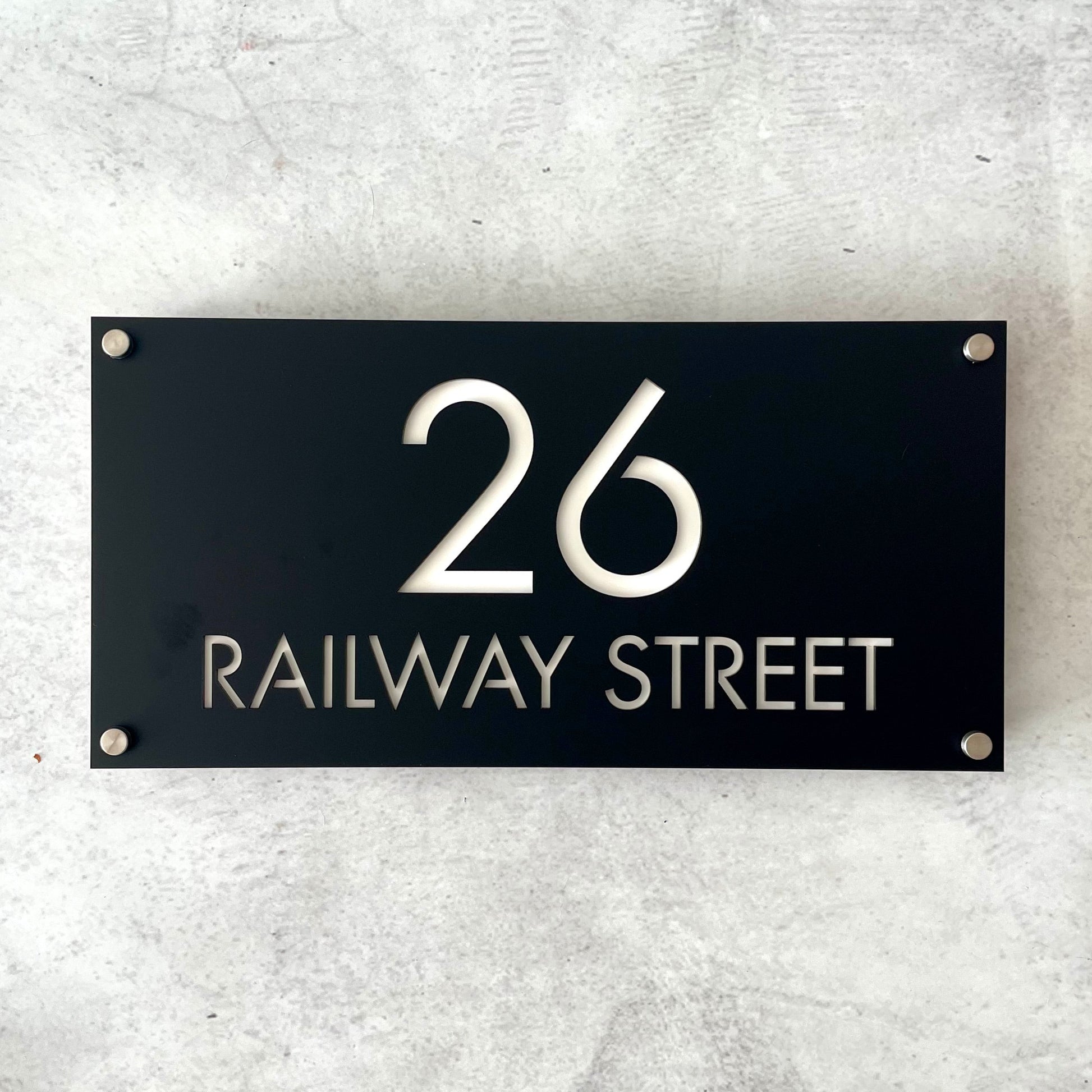 Modern black address sign mounted on grey wall