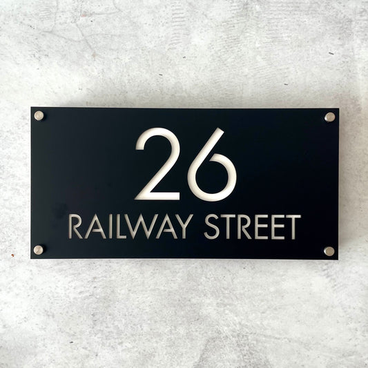 Modern black address sign mounted on grey wall