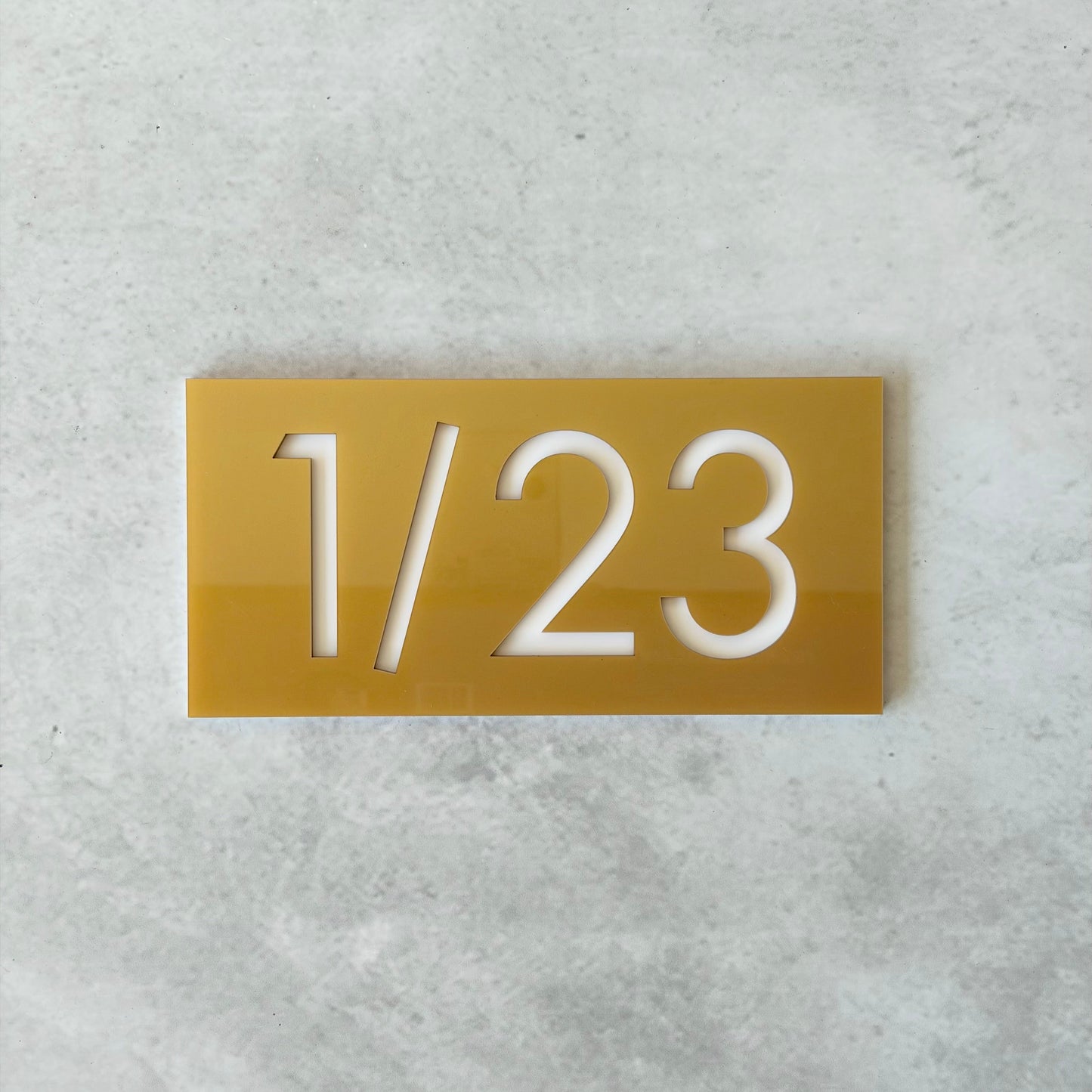 Gold rectangular plate with white unit number