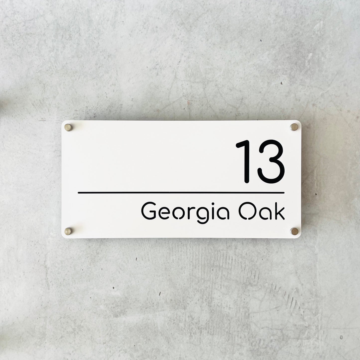 Floating address sign offset from grey concrete wall