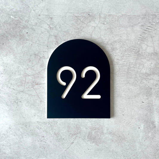 Contemporary house numbers on an arch-shaped plaque