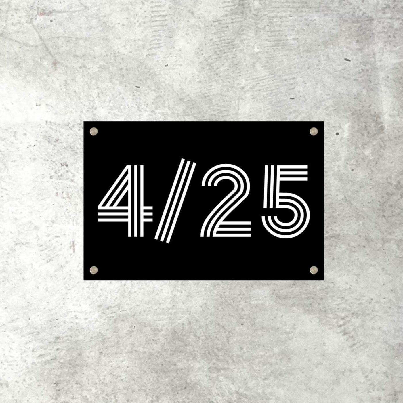 Black house number sign with '4/25' on a textured grey background