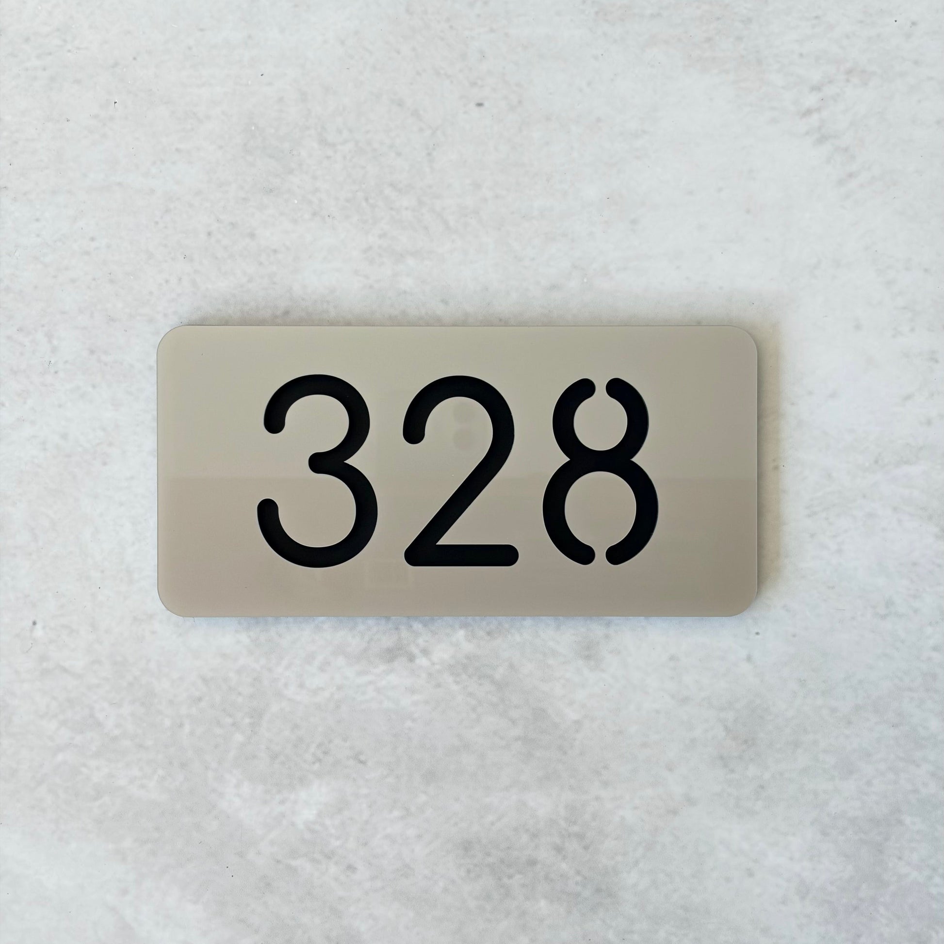 Rectangular silver acrylic sign with the number '328' on a textured white background