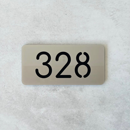 Rectangular silver acrylic sign with the number '328' on a textured white background