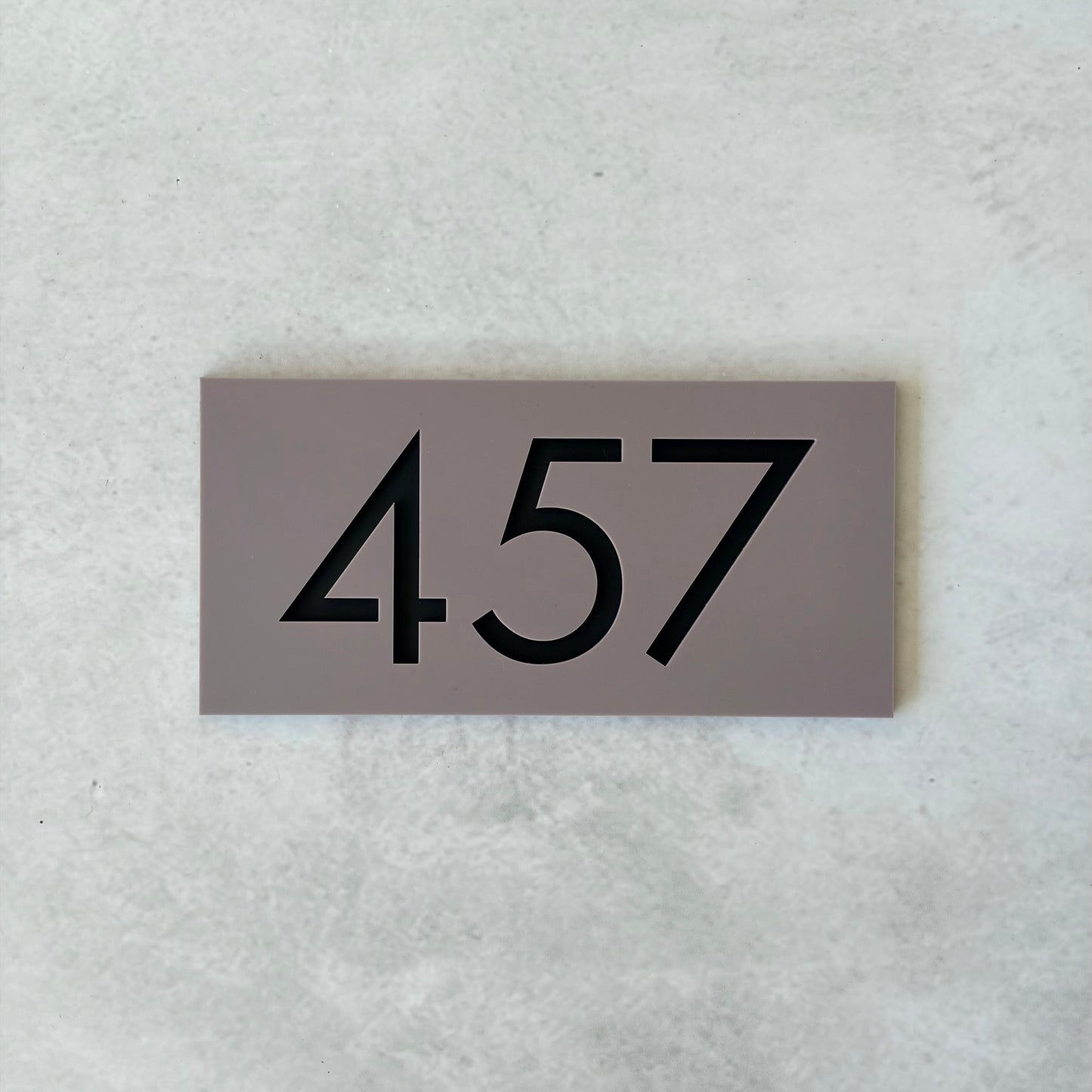 grey acrylic unit number sign with black text