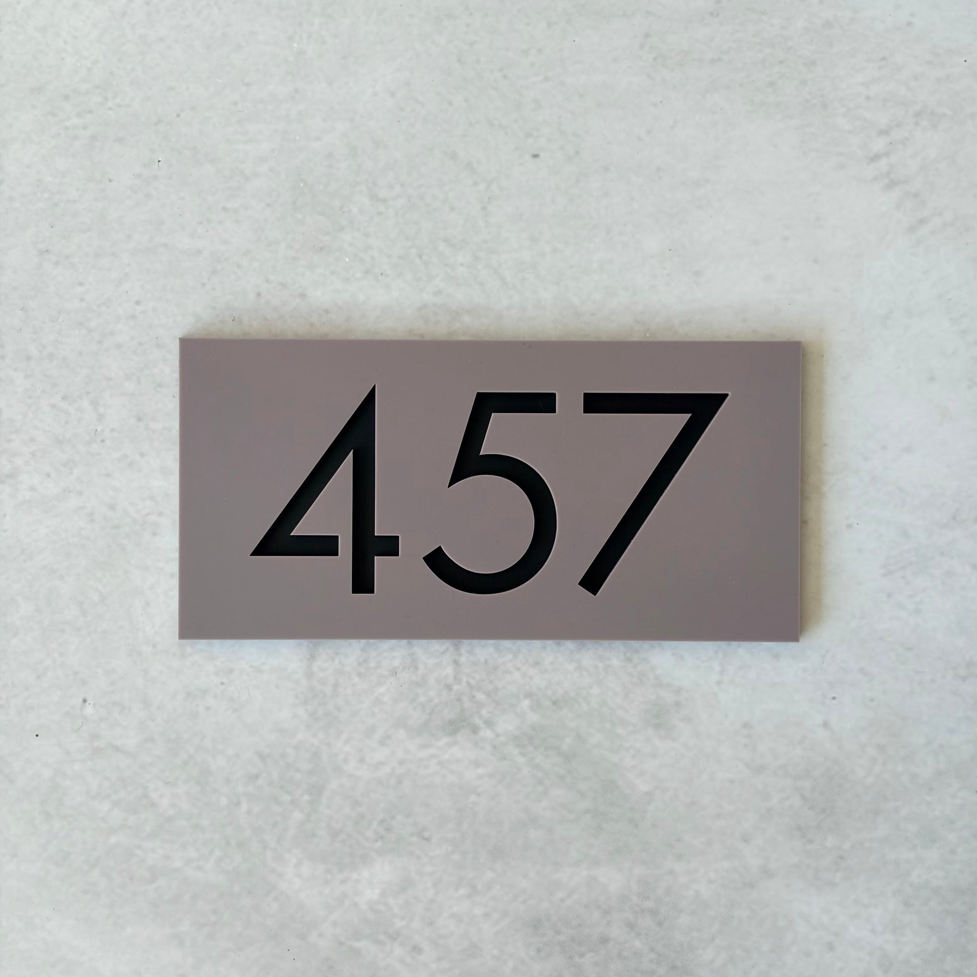 grey acrylic unit number sign with black text