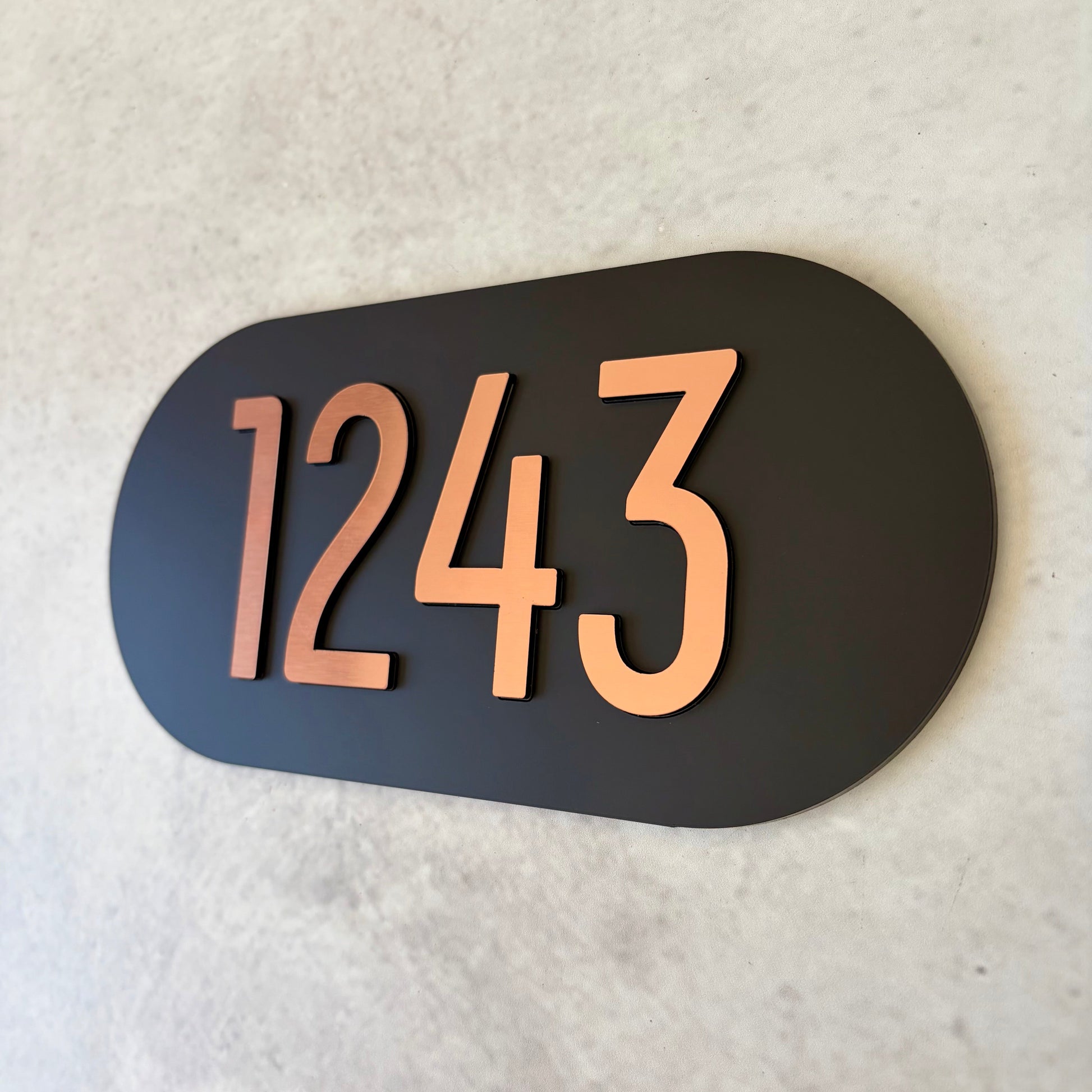Oval unit number sign with '1243' on a black background