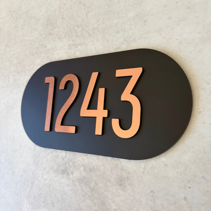 Oval unit number sign with '1243' on a black background