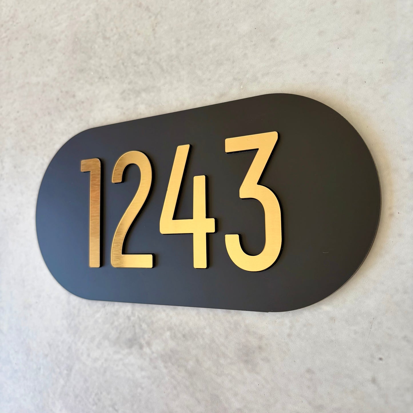Black plaque with brushed gold numbers